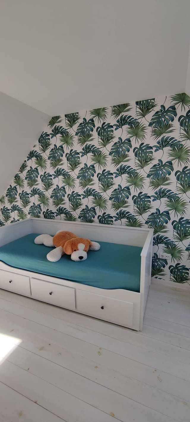 Levélmintás tapéta egy tetőtéri gyerekszobában